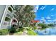 Scenic view of the community clubhouse, gym, and pool overlooking a tranquil lake on a bright, sunny day at 2314 Mid Town Ter # 1126, Orlando, FL 32839