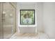 Elegant bathroom with a soaking tub and large window at 2412 Chantilly Ave, Winter Park, FL 32789