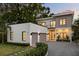 Modern two-story home exterior showcasing a three-car garage, lush landscaping, and contemporary design at 2412 Chantilly Ave, Winter Park, FL 32789