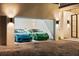 Open garage showcasing a blue and green sports car parked inside with modern lighting and gravel driveway at 2412 Chantilly Ave, Winter Park, FL 32789