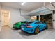 Clean garage featuring epoxy floors, two luxury sports cars, and an open garage door at 2412 Chantilly Ave, Winter Park, FL 32789