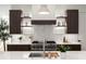 Modern kitchen featuring dark cabinets, a stainless steel range hood, and ample counter space at 2412 Chantilly Ave, Winter Park, FL 32789