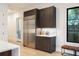 Kitchen area with modern stainless steel refrigerator and dark cabinets at 2412 Chantilly Ave, Winter Park, FL 32789