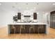Well-lit kitchen with a center island featuring bar seating and modern pendant lighting at 2412 Chantilly Ave, Winter Park, FL 32789