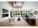Bright and airy living room with hardwood floors, a wood tray ceiling and views of the pool at 2412 Chantilly Ave, Winter Park, FL 32789