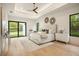 Bright primary bedroom features a large bed, recessed ceiling, backyard views and hardwood flooring at 2412 Chantilly Ave, Winter Park, FL 32789