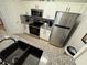 Modern kitchen with stainless steel appliances, white cabinets, granite countertops, and black hardware, offering a sleek design at 2778 Almaton Loop # 302, Kissimmee, FL 34747