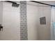 Modern shower with a rainfall showerhead, gray tile, and decorative accent tile in the alcove at 2778 Almaton Loop # 302, Kissimmee, FL 34747