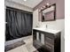 This is a full bath with a dark vanity, toilet and full shower at 2809 Pioneer Rd, Orlando, FL 32808