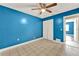 Bedroom featuring tile floors, blue walls, a ceiling fan, and a closet at 2809 Pioneer Rd, Orlando, FL 32808