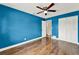 Bedroom featuring hardwood floors, blue walls, a ceiling fan, and a closet at 2809 Pioneer Rd, Orlando, FL 32808
