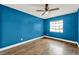 Bedroom featuring hardwood floors, a ceiling fan, a window and blue painted walls at 2809 Pioneer Rd, Orlando, FL 32808