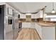 Kitchen featuring stainless steel appliances, white cabinets, and wood tile floors at 2809 Pioneer Rd, Orlando, FL 32808