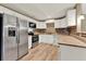 Modern kitchen featuring stainless steel appliances, granite countertops, and wooden-look tile floor at 2809 Pioneer Rd, Orlando, FL 32808