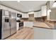Kitchen featuring stainless steel appliances, white cabinets, and wood tile floors at 2809 Pioneer Rd, Orlando, FL 32808
