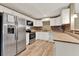 Modern kitchen featuring stainless steel appliances, granite countertops, and wooden-look tile floor at 2809 Pioneer Rd, Orlando, FL 32808