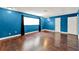 Living room featuring hardwood floors, blue painted walls, and dark colored curtains at 2809 Pioneer Rd, Orlando, FL 32808