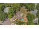 Aerial view of the house with a pool and backyard fire pit surrounded by mature trees at 300 Hickory Ct, Apopka, FL 32712