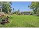 Large backyard with mature trees, a gray exterior, a deck, a patio, a pool, and a log pile at 300 Hickory Ct, Apopka, FL 32712