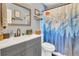 This bathroom features a gray vanity with dual sinks and a decorative shower curtain at 300 Hickory Ct, Apopka, FL 32712