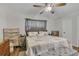 This bedroom has a ceiling fan, window with curtains and dresser and nightstand for storage at 300 Hickory Ct, Apopka, FL 32712
