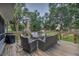 Outdoor deck with patio seating, grill, view of backyard, and lush mature trees at 300 Hickory Ct, Apopka, FL 32712