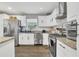 This kitchen has white cabinets, granite countertops, and stainless steel appliances at 300 Hickory Ct, Apopka, FL 32712