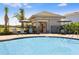 Community pool with seating areas, umbrellas, and well-maintained landscaping at 306 Wayland Dr, Haines City, FL 33844