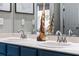 Bathroom featuring dual sinks, a framed mirror, and attractive wood decor at 3400 Rose Mallow Loop, Oviedo, FL 32766