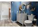 Coastal-themed half bathroom with blue walls, wooden-look floors, and a decorative vanity and fixtures at 3400 Rose Mallow Loop, Oviedo, FL 32766