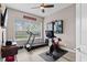 Bright exercise room with a treadmill, spin bike, wood-look floors, and a ceiling fan at 3400 Rose Mallow Loop, Oviedo, FL 32766