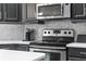Close-up of modern kitchen with stainless steel appliances, countertops and stylish backsplash at 3400 Rose Mallow Loop, Oviedo, FL 32766