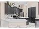 Modern kitchen features dark cabinetry, stainless steel appliances, and a spacious island with bar seating at 3400 Rose Mallow Loop, Oviedo, FL 32766