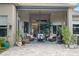 Covered outdoor lanai with comfortable seating, lush plants, and stone flooring at 3400 Rose Mallow Loop, Oviedo, FL 32766