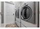A modern laundry room featuring a front-load washer and dryer, with a neutral color palette at 3400 Rose Mallow Loop, Oviedo, FL 32766