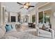 Open-concept living space with wood floors, a ceiling fan, and access to the kitchen and dining area at 3400 Rose Mallow Loop, Oviedo, FL 32766