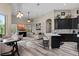 Modern living area connecting to the kitchen with sleek island, cozy seating, and natural light at 3400 Rose Mallow Loop, Oviedo, FL 32766
