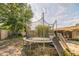 Backyard with a trampoline and solar panels, enclosed by a wooden fence and mature trees, under a partly cloudy sky at 3711 Shady Grove Cir, Orlando, FL 32810