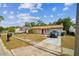 Single-story home with a red front door and driveway with vehicles parked in front at 3711 Shady Grove Cir, Orlando, FL 32810