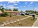 Single-story home with a red front door and driveway with vehicles parked in front at 3711 Shady Grove Cir, Orlando, FL 32810