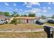 Charming single-story home with a red front door, a cozy front yard, and driveway at 3711 Shady Grove Cir, Orlando, FL 32810