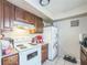 Functional kitchen with white appliances, wooden cabinets, and a tile floor at 3711 Shady Grove Cir, Orlando, FL 32810