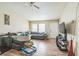 Cozy living room with wood-look floors, a ceiling fan, and a comfortable gray sectional sofa at 3711 Shady Grove Cir, Orlando, FL 32810