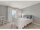 Neutral bedroom features a white bed frame, chair, gray walls and window at 38 Da Rosa Ave, Debary, FL 32713