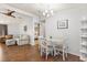 Cozy dining area with wood floors, a round table, and white chairs with a chandelier and view to the living room at 38 Da Rosa Ave, Debary, FL 32713