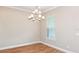 Dining room with a modern chandelier, tile floors, and a large window for natural light at 4204 Barbuda Ln, Kissimmee, FL 34758