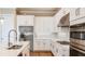 Sleek kitchen featuring stainless steel appliances, quartz counters, white cabinetry, and a center island at 4204 Barbuda Ln, Kissimmee, FL 34758
