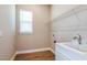 Bright laundry room with wood-look tile flooring, a sink, and shelving at 4204 Barbuda Ln, Kissimmee, FL 34758