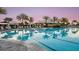 Resort-style pool with palm trees, cabanas, and lounge chairs, offering a luxurious experience at 4204 Barbuda Ln, Kissimmee, FL 34758