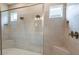 Walk-in shower boasting dual showerheads, tiled walls, and small windows for natural light at 4204 Barbuda Ln, Kissimmee, FL 34758